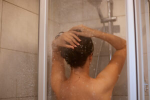 woman washing her hair using natural shampoo from soap factory